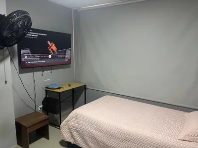 a bedroom with a bed and a flat screen tv at Gisela Wax More Hostel in Cartagena de Indias