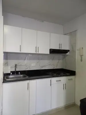 a white kitchen with a sink and white cabinets at Apt Edificio los Delfines Playa in Cartagena de Indias
