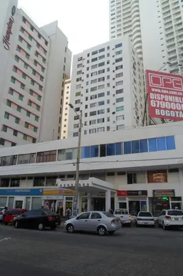 a parking lot with cars parked in front of a building at Apt Edificio los Delfines Playa in Cartagena de Indias