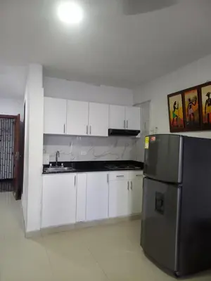 a kitchen with white cabinets and a stainless steel refrigerator at Apt Edificio los Delfines Playa in Cartagena de Indias
