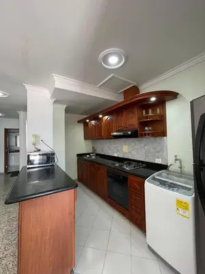 a kitchen with wooden cabinets and black counter tops at Two Bedroom Apt in Cartagena de Indias