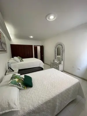 a hotel room with two beds and a mirror at Two Bedroom Apt in Cartagena de Indias
