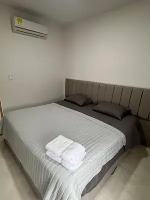a bed with a white towel on it in a room at Villa Sabanilla Casa bifamiliar campestre con piscina privada Aire acondicionado Tranquilidad total in Puerto Colombia