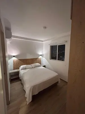 a bedroom with a white bed and a window at New apartment 5 minutes from the beach in Cartagena de Indias