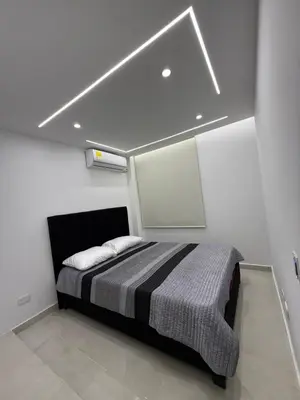 a bedroom with a bed in a white room at Apartamento exclusivo y nuevo en el norte de Barranquilla in Barranquilla