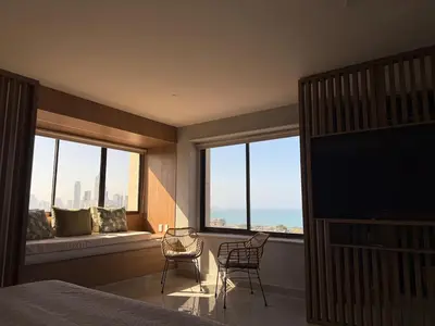 a bedroom with a bed and two chairs and a large window at NEW Unique 270º view above the city walls in Cartagena de Indias
