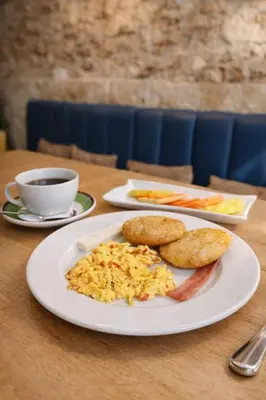 a table with two plates of food and a cup of coffee at Hotel Getsemaní Central in Cartagena de Indias