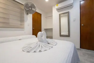 a bedroom with a white bed with a dress on it at Hotel Getsemaní Central in Cartagena de Indias