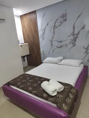 a bedroom with a bed with towels on it at Hotel El Tesoro in Barranquilla