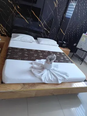 two beds with white sheets and a scarf on them at Hotel El Tesoro in Barranquilla