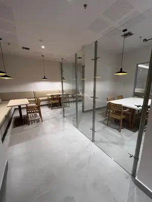 a room with a table and some chairs and a table and glass partition at Terraza del Mar in Santa Marta