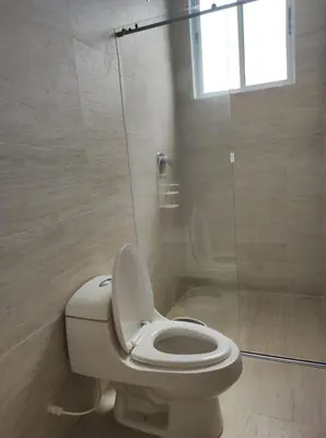 a bathroom with a toilet and a shower with a window at Apto Coveñas in Coveñas