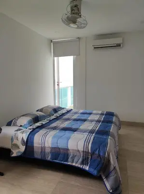 a bed in a white room with a window at Apto Coveñas in Coveñas