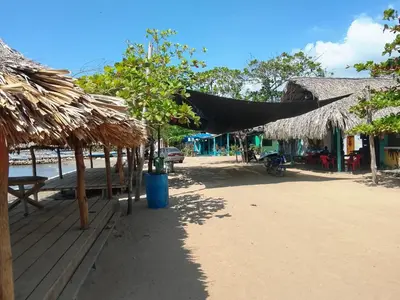 a group of umbrellas and tables on a beach at Hotel Pesquera rincon berrugas in Berrugas