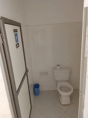 a white bathroom with a toilet and a door at Hotel Pesquera rincon berrugas in Berrugas