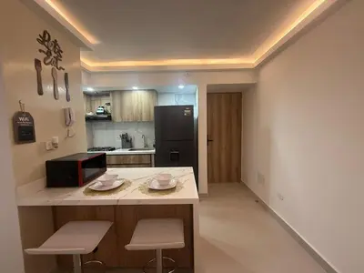 a kitchen with a counter with two chairs and a microwave at Apartamento con cercania al Mar y centro historico in Cartagena de Indias