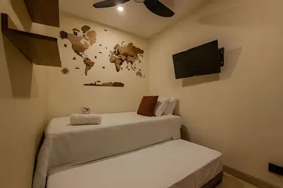 a room with two beds and a flat screen tv at Colonial Elegance in Historic Center /Pool in Cartagena de Indias