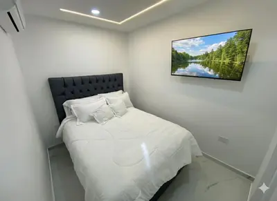 a bedroom with a bed with a picture on the wall at Apto de 3 habitaciones cerca del areopuerto de CTG in Cartagena de Indias