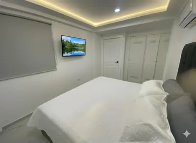 a bedroom with a bed with a tv on the wall at Apto de 3 habitaciones cerca del areopuerto de CTG in Cartagena de Indias