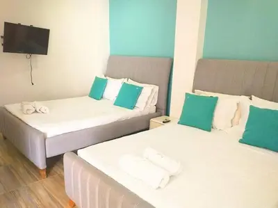 two beds with green and white pillows in a room at apartamentos amoblados o hotel en Cartagena para arriendo por día desde 330 mil pesos hasta 600 mil mil pesos colombianos in Cartagena de Indias