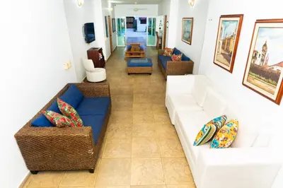a living room with a white couch and chairs at Country cabin, Coveñas in Coveñas
