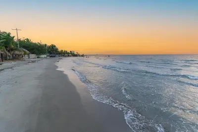 an empty beach at sunset with the ocean at Country cabin, Coveñas in Coveñas