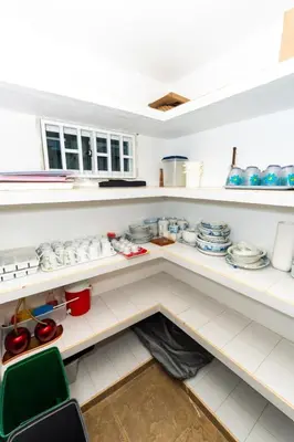 a kitchen with white shelves with dishes on them at Country cabin, Coveñas in Coveñas