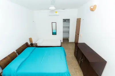 a bedroom with a blue bed in a room at Country cabin, Coveñas in Coveñas