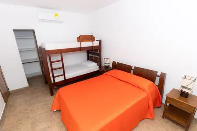 a bedroom with a bed with an orange bedspread at Country cabin, Coveñas in Coveñas