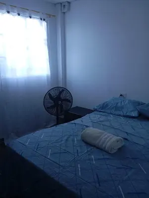 a blue room with a bed and a fan at Tefi beach in Puerto Colombia