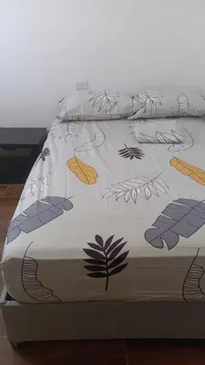 a bed with a comforter on top of it at Tefi beach in Puerto Colombia