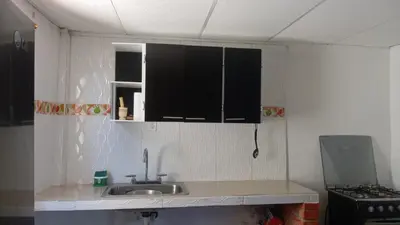a kitchen with a sink and black cabinets at Tefi beach in Puerto Colombia