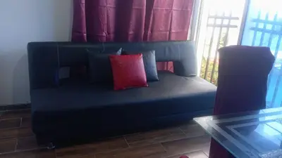 a blue couch with a red pillow in a room at Tefi beach in Puerto Colombia