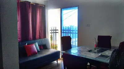 a living room with a table and a couch and a window at Tefi beach in Puerto Colombia
