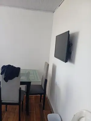 a dining room with a table and a tv on the wall at Tefi beach in Puerto Colombia