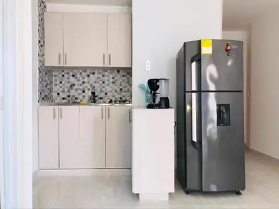 a kitchen with a stainless steel refrigerator and white cabinets at Cartagena Sotavento Laguito in Cartagena de Indias