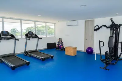 a gym with three treadmills and a blue floor at OceanDrive509 in Cartagena de Indias