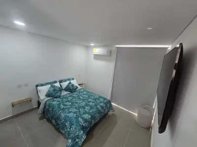 a small bedroom with a bed with a blue blanket at OceanDrive509 in Cartagena de Indias