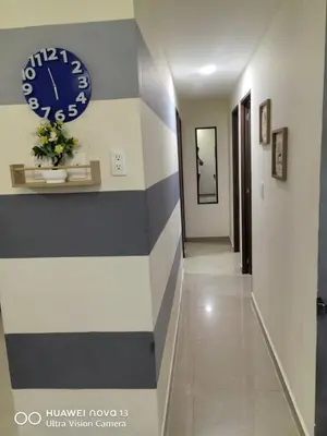 a hallway with a clock on a wall at Lujoso Apartamento en Cartagena in Cartagena de Indias
