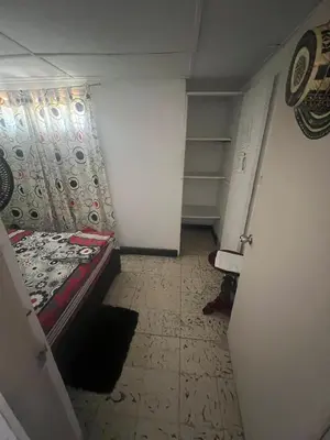 a small room with a bed and a closet at Carnival Hostel BAQ in Barranquilla
