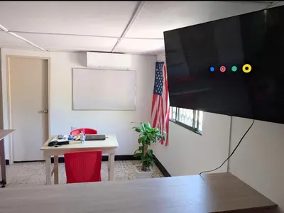 an office with a desk and a tv on a wall at Carnival Hostel BAQ in Barranquilla