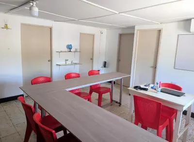 a conference room with red chairs and a long table at Carnival Hostel BAQ in Barranquilla