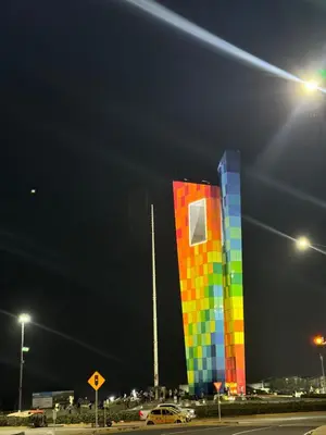 a building with a colorful in a street at night at CARIBE STAY - Apto in Barranquilla