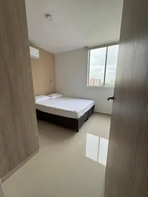 a small bedroom with a bed and a window at CARIBE STAY - Apto in Barranquilla