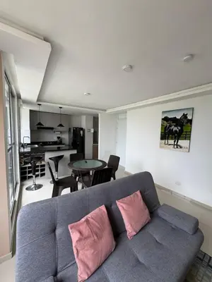 a living room with a gray couch with pink pillows at CARIBE STAY - Apto in Barranquilla