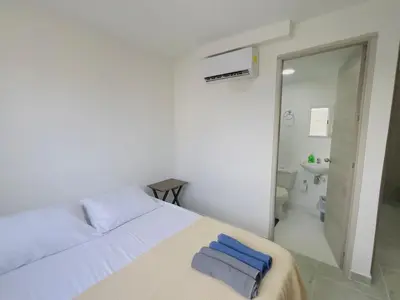 a white bedroom with a bed and a bathroom at Beach Lotus 1203 in Cartagena de Indias