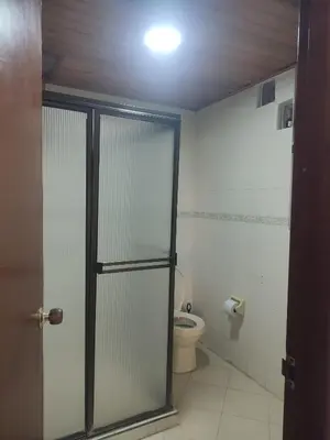 a bathroom with a toilet and a glass door at Oasis del Manglar in Cartagena de Indias