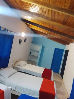 a bedroom with two beds and a blue door at Hotel Palma Azul in Coveñitas