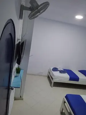 a small room with a bed and a tv at Hotel Palma Azul in Coveñitas