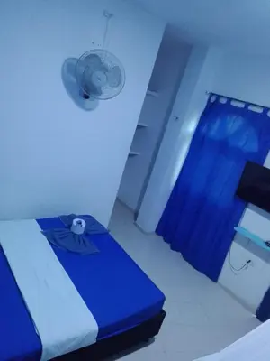 a bedroom with a blue bed and a blue curtain at Hotel Palma Azul in Coveñitas
